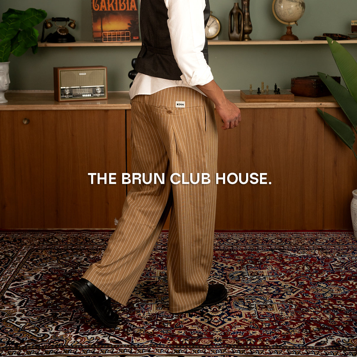 Model wearing Brun Clubhouse Collection apparel inspired by heritage sportswear, featuring tailored silhouettes, premium fabrics, and vintage clubhouse detailing in a refined modern setting.